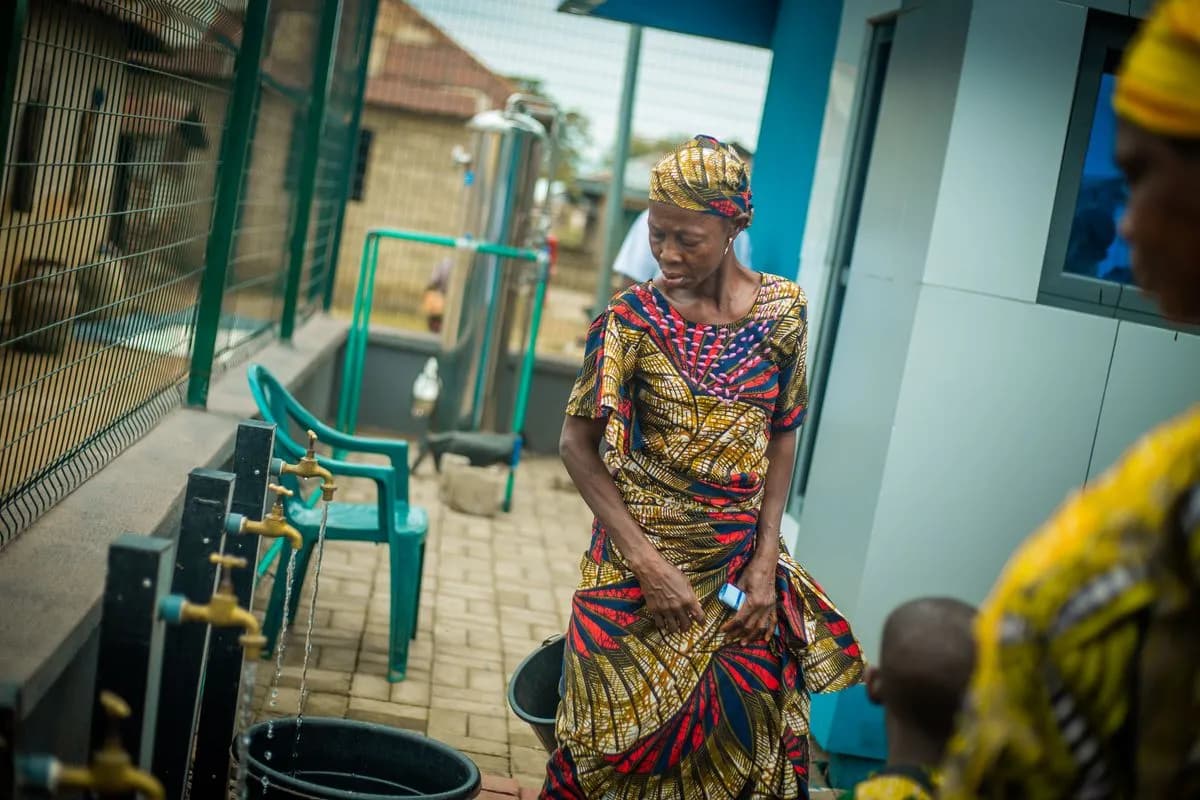 A community member collecting clean water at a Fairaction Smart Water Kiosk.
