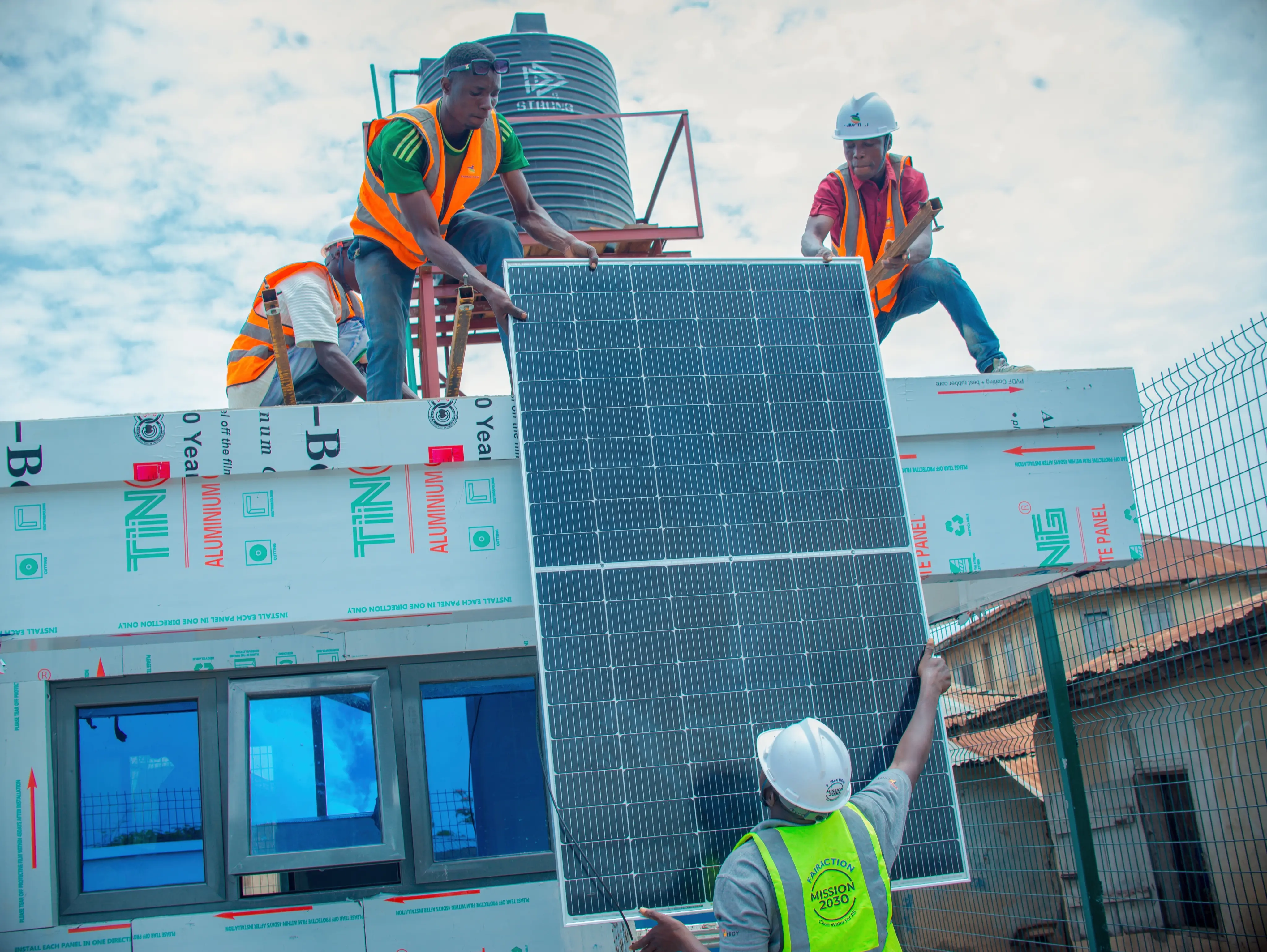 Workers installing rooftop solar panels